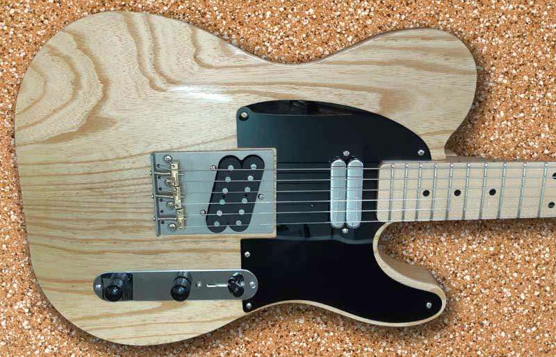 Natural wood guitar body with black pick guard.