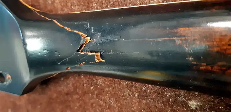 Cracked Headstock Repair Assessment Close-up view of a dark finish Gibson Les Paul guitar neck showing a severe fracture and wood crack near the headstock junction.