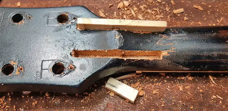 Headstock Splinting Repair Process Overhead view of a Gibson Les Paul guitar headstock with routed channels and wooden splints being fitted to reinforce a broken neck joint at Tim Marten Repairs.