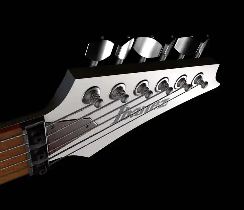 Close-up of a white Ibanez electric guitar headstock showing tuning pegs, locking nut, and silver logo.