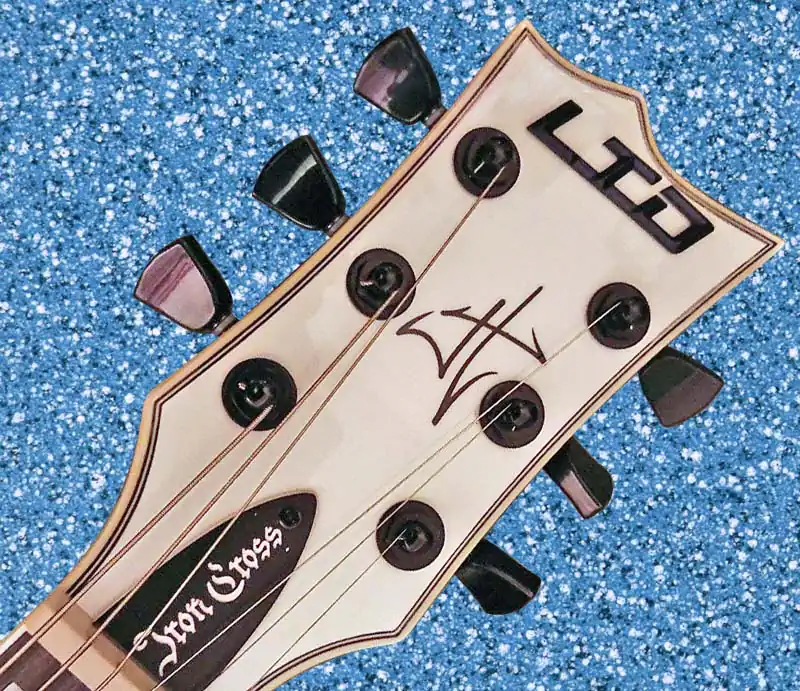 Close-up of an ESP LTD Iron Cross James Hetfield signature electric guitar headstock with black tuners.