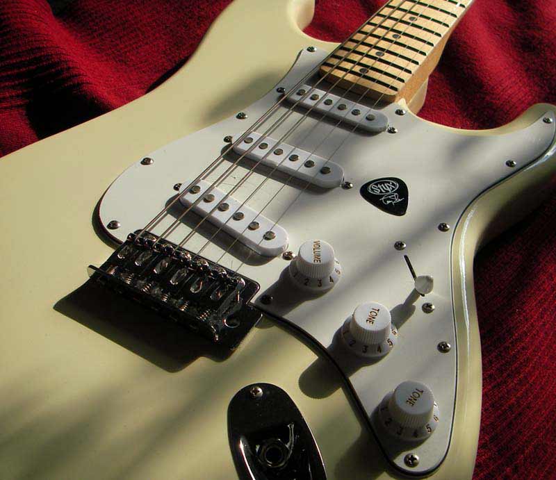 Close up of guitar's cream body.